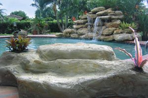 Pool with fountain and tropical landscape design in Miami