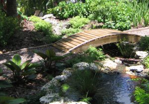 Landscape design featuring a small bridge over a water feature in Key Biscayne, FL